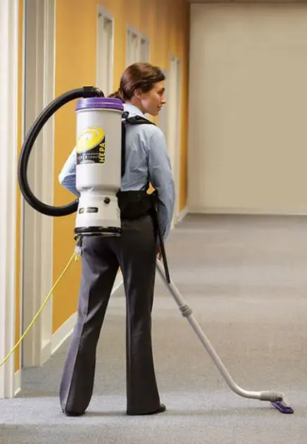 professional cleaner using a back vacuum in commecail space